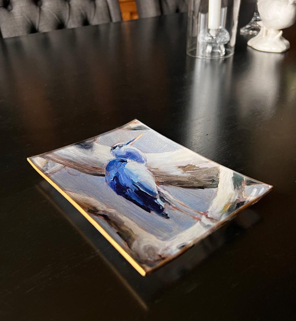 Decorative plate with a blue bird design on a dark surface