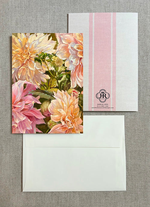 A floral greeting card with large pink and cream flowers, shown with a white envelope and a white postcard featuring pink vertical stripes and a small 'JR' monogram.