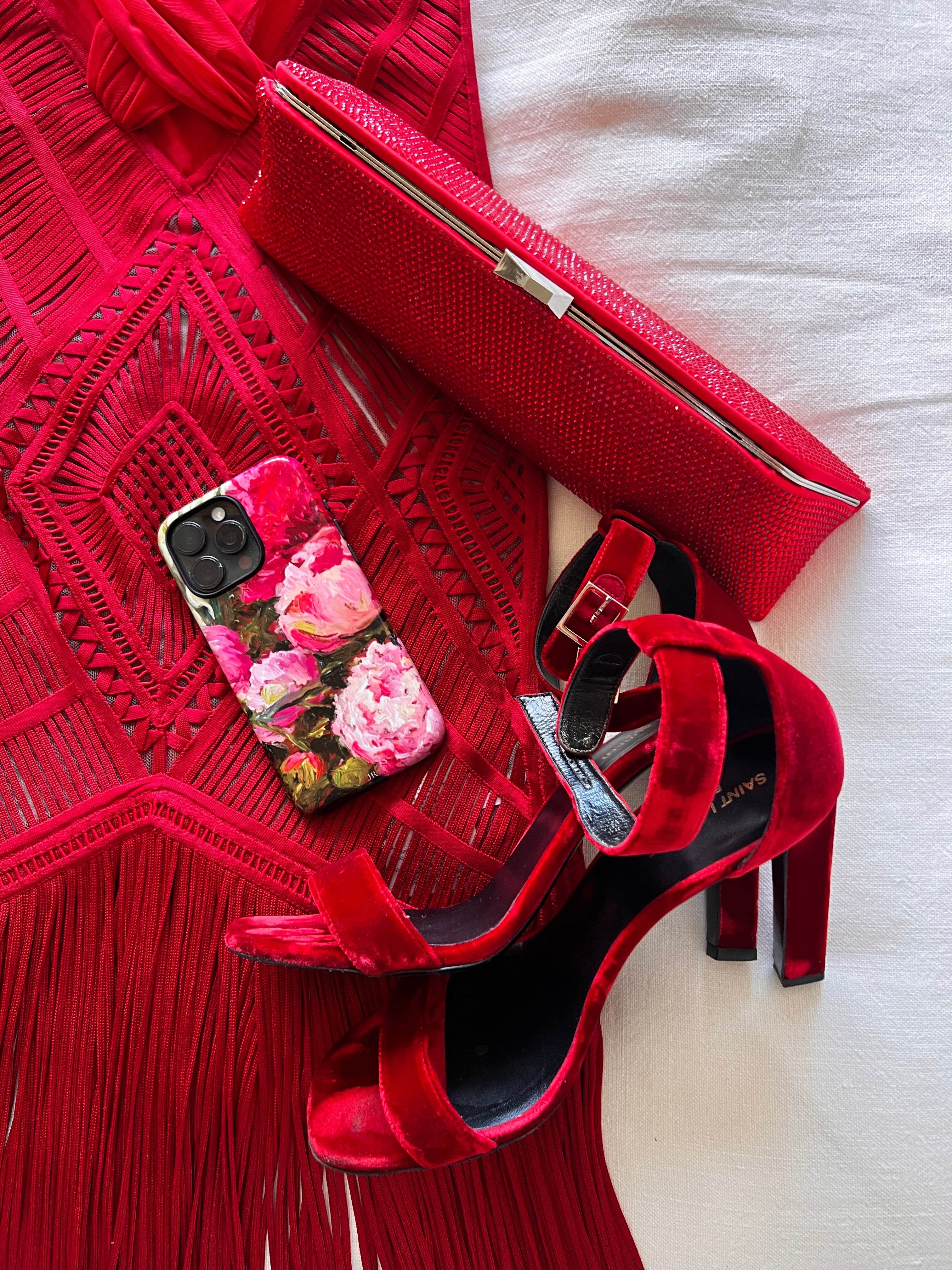 Red high-heeled shoes with J'Adore floral phone case on a red dress with red clutch.