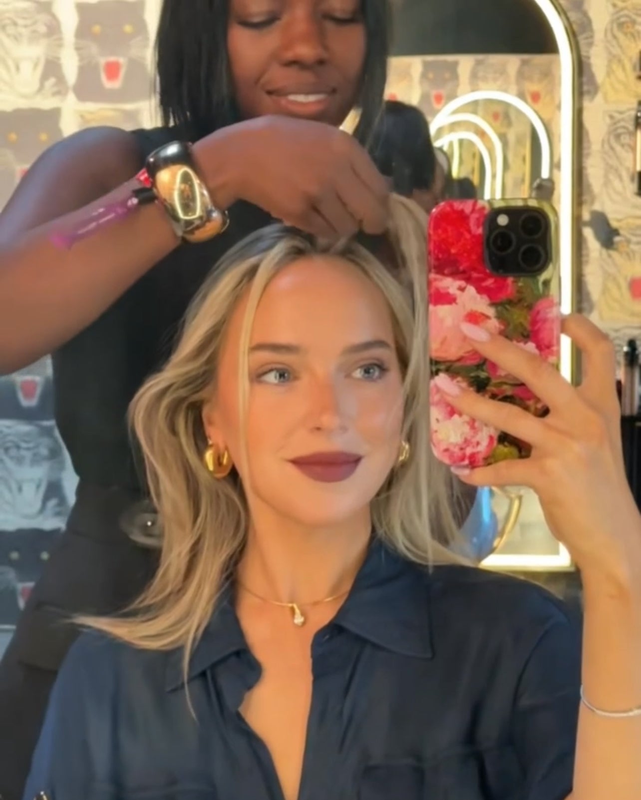 Greta Rolli getting her hair styled by a professional in a salon setting taking selfie with J'Adore phone case