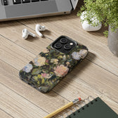 iPhone 13 Pro case on a desk featuring a budding peony painting by artist Jennifer Hansen Rolli.