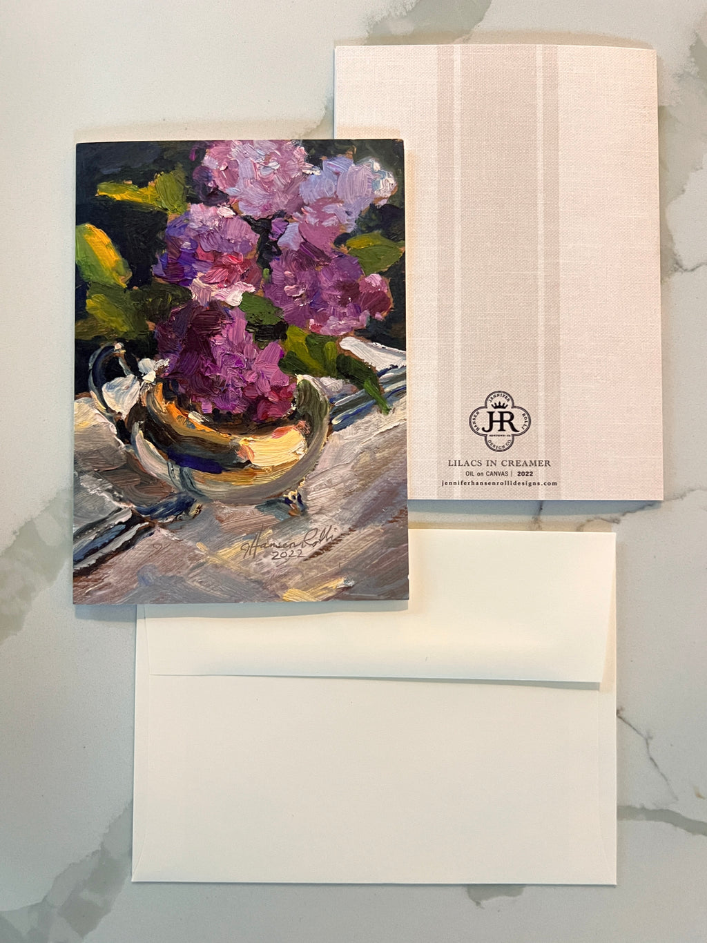 Note card with floral painting and matching envelope on a marble surface