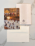 Greeting card with a winter scene of people skating on an ice rink, featuring a envelope with a logo.