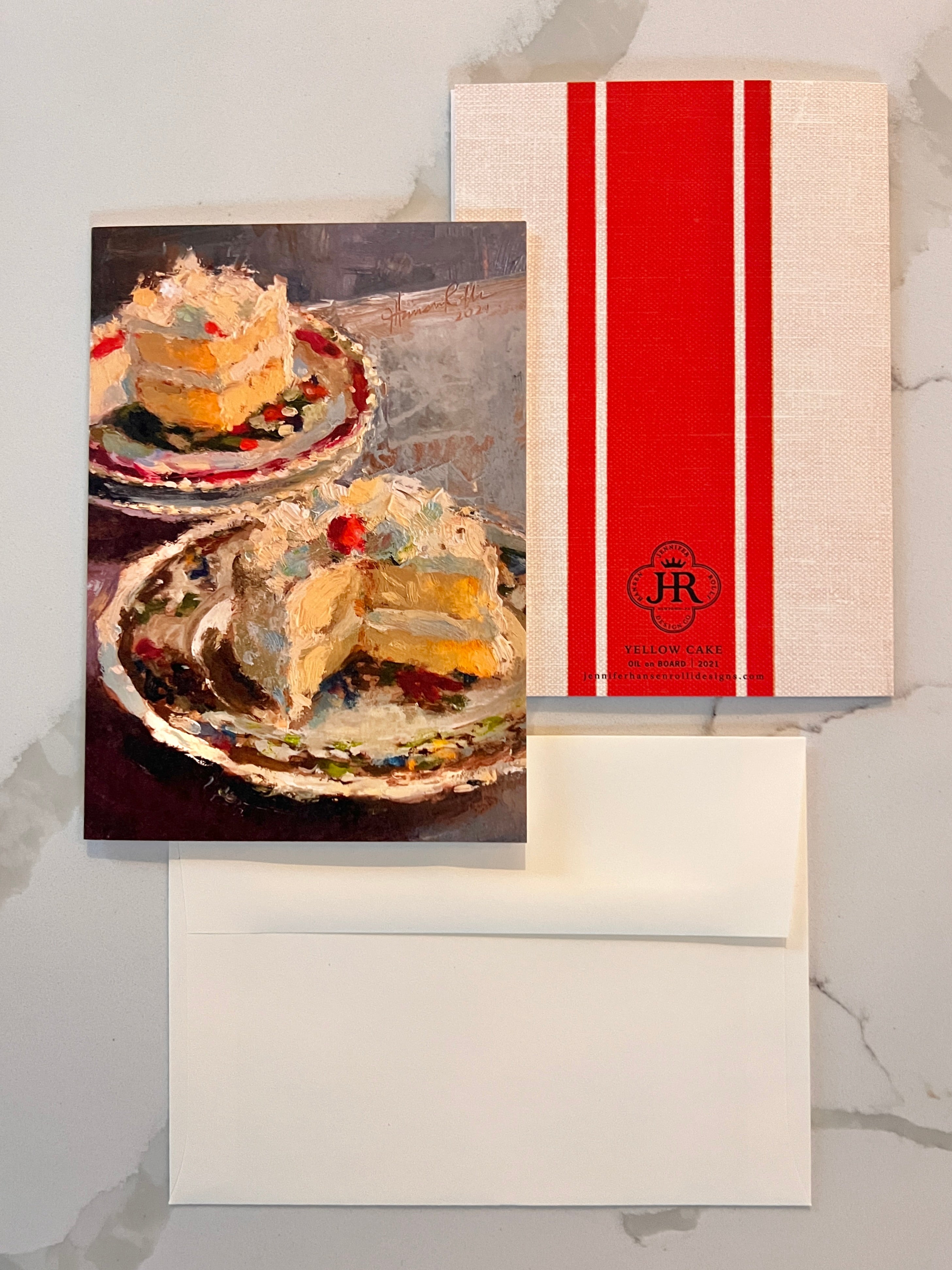 Greeting card with a slice of cake and a red and white striped back side on a marble surface.