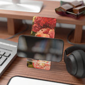 A pink peony phone stand with phone by artist Jennifer Hansen Rolli.