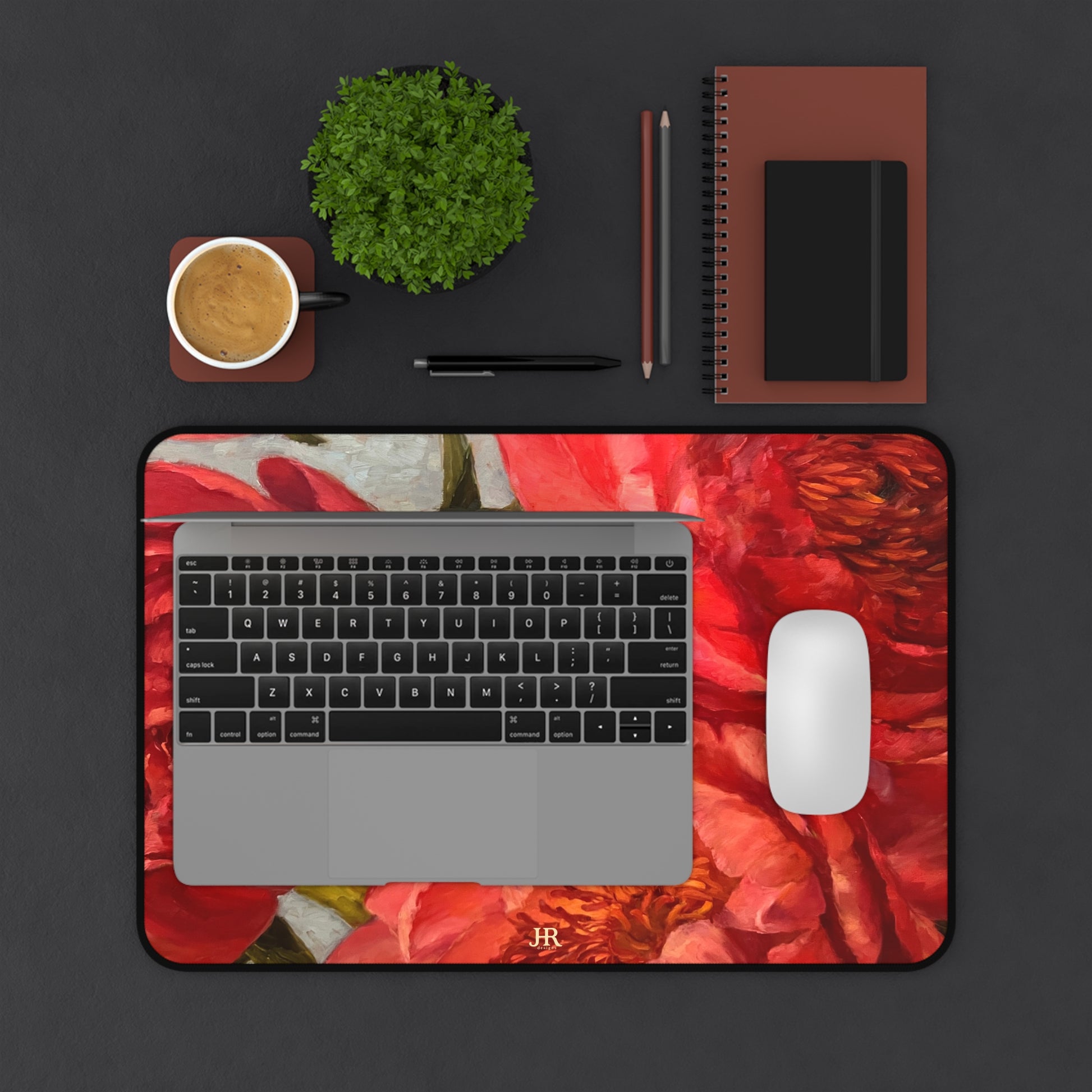 A birds eye view of a desk set up with the red peony mat by artist Jennifer Hansen Rolli.