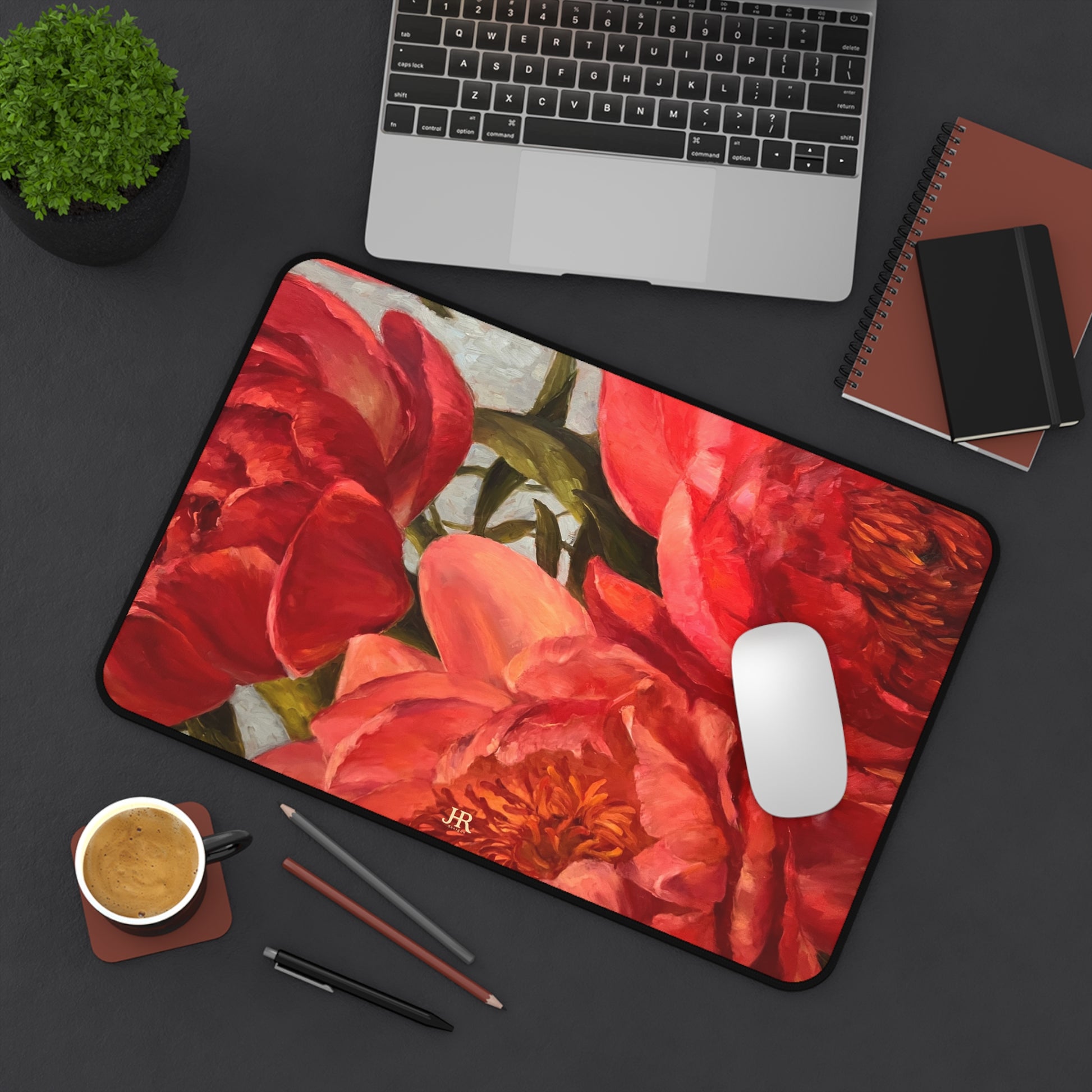 A birds eye view of an office desk set up with the red peony mat by artist Jennifer Hansen Rolli.