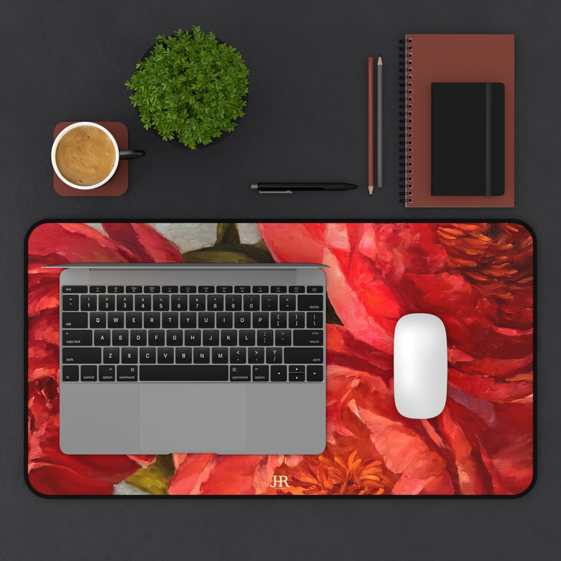 A birds eye view of a desk set up with the large red peony mat by artist Jennifer Hansen Rolli.