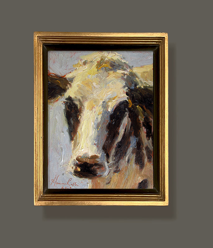 A gold framed Sterotypical cow painting by artist Jennifer Hansen Rolli.