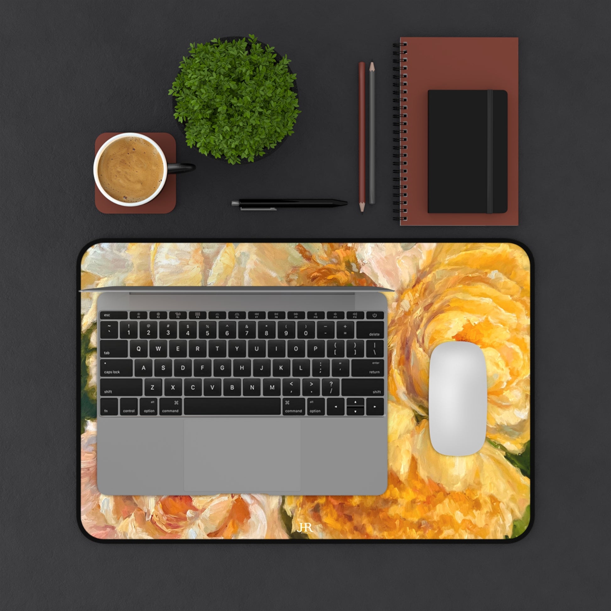 A birds eye view of a desk set up with the yellow peony mat by artist Jennifer Hansen Rolli.